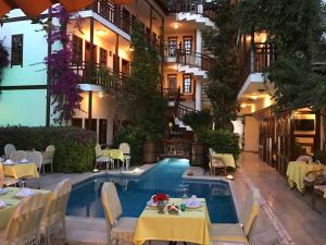 a hotel with a pool and tables and a restaurant at Hotel Karyatit Kaleici in Antalya