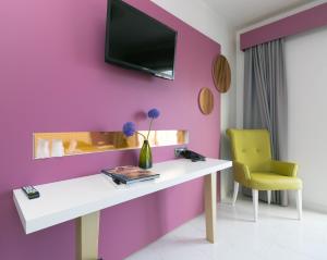 a room with a white table and a tv on a pink wall at The Purple Hotel - Adults Only in San Antonio