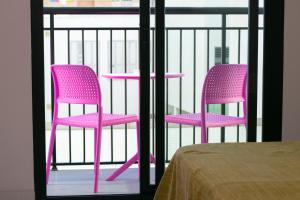 two pink chairs sitting on top of a balcony at The Purple Hotel - Adults Only in San Antonio