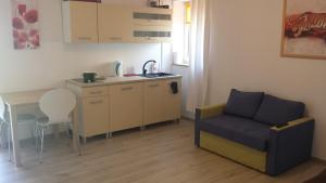 ルビャトボにあるNowy Apartamentのリビングルーム(ソファ、テーブル付)、キッチンが備わります。