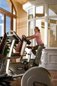 a woman on a treadmill in a gym at Yachthafenresidenz Hohe Düne in Warnemünde