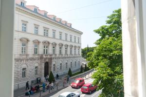 a building with cars parked in front of a street at Indigo Inn Rooms in Split