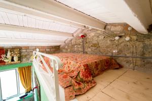 um quarto com uma cama numa parede de pedra em La Limonaia em San Venanzo