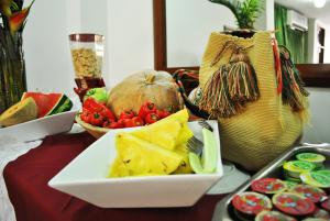 un tavolo con un piatto di cibo e un cesto di frutta di Hotel Majayura Sol a Ríohacha