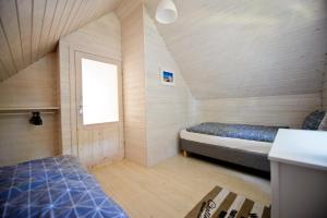 a small room with two beds and a window at Domki Na Brackiej in Pobierowo
