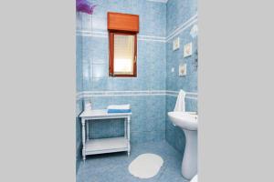 a blue bathroom with a sink and a toilet at Apartman 1 in Podstrana