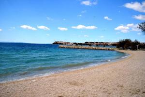 a beach with the ocean and a rocky pier at Apartman 1 in Podstrana +5 photos