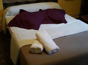a bed with a white towel on top of it at Hotel Du Square in Riom