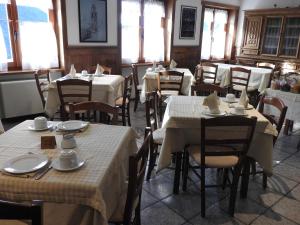 シャンポルクにあるHotel Le Clocherのダイニングルーム(テーブル、椅子、白い料理付)