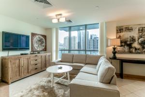 a living room with a couch and a tv at One Perfect Stay - Marina Terrace in Dubai