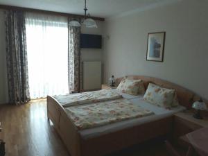 a bedroom with a bed and a large window at Gasthaus Kirchenwirt in Koppl
