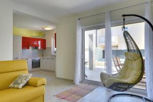 ein Wohnzimmer mit einer gelben Couch und einer Schaukel in der Unterkunft Holiday Home Baldini in Banjole