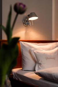 ein Schlafzimmer mit einem Bett mit einer Lampe und einem Kissen in der Unterkunft Historik Hotel Garni Christinenhof in Hameln