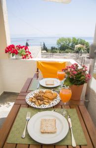 uma mesa com pratos de comida e copos de sumo de laranja em Apartments MARGARITA Kaizer Bridge em Achílleion