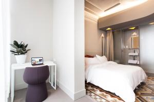 バルセロナにあるデスティネーションBCN ウニヴェルシタット ルームズのベッドルーム1室(ベッド1台、テーブル、椅子付)