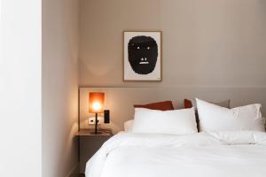 a bedroom with a bed with a black mask on the wall at DestinationBCN - Universitat Rooms in Barcelona