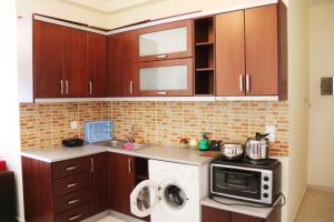 een keuken met houten kasten en een magnetron bij Tarace sea view apartment in Sarandë