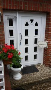 a white door with a flower pot in front of it at Ferienwohnung-Bullendorf in Bullendorf