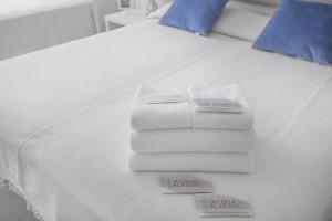 a pile of towels sitting on top of a bed at Locanda Kon Tiki in Alassio +21 photos