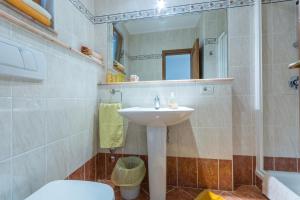 a bathroom with a sink and a toilet and a mirror at Guesthouse Casa Nova in Poreč