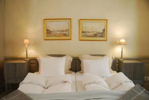 uma cama com lençóis brancos e almofadas num quarto em Hotel Sven Vintappare em Estocolmo