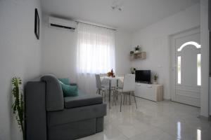 a living room with a couch and a table with chairs at Apartman Fantasy in Trogir