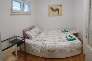 a small bedroom with a bed with a zebra picture on the wall at Apartment Homey in Zadar