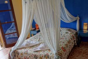 a bedroom with a bed with a canopy at Cretan Village Hotel in Agios Nikolaos