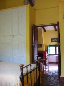 Cortijo El Berrocal في كازالا دي لا سييرا: غرفة نوم مع باب أبيض كبير وسرير