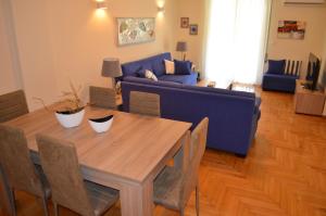 uma sala de estar com uma mesa e um sofá azul em Pedion Areos Park 6 Center 6 em Atenas
