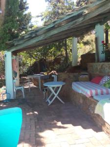 eine Terrasse mit einem Tisch, einer Bank und einem Tisch in der Unterkunft Cortijo El Berrocal in Cazalla de la Sierra