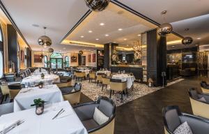 a restaurant with white tables and chairs and a bar at Baglioni Hotel London - The Leading Hotels of the World in London