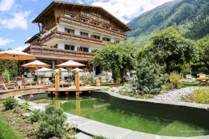 un hôtel avec un étang en face d'un bâtiment dans l'établissement Chalet-Hôtel Hermitage, à Chamonix-Mont-Blanc