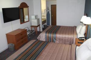 a hotel room with two beds and a television at Columbus Inn in Columbus