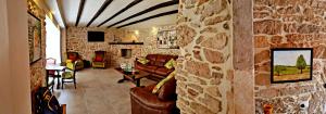 a living room with leather furniture and a stone wall at Villa Cherie in Sutomišćica
