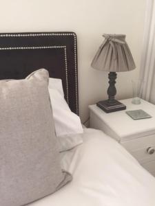 a bed with a pillow and a lamp on a nightstand at The Beaufort, Raglan in Raglan