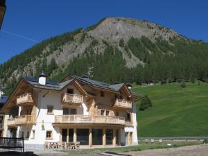 duży budynek z górą w tle w obiekcie B&B Ecohotel Chalet des Alpes w Livigno