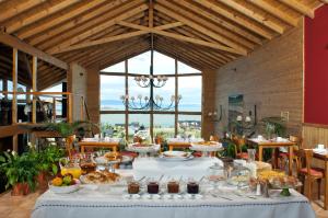 uma sala de jantar com uma mesa cheia de comida em Blanca Patagonia Hostería Boutique y Cabañas em El Calafate