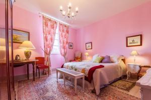 a bedroom with pink walls and a bed and a desk at Chambres d'Hôtes Saint Roch in Tournecoupe +46 photos