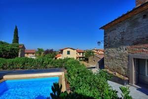 uma piscina num quintal ao lado de um edifício em La Fonte by PosarelliVillas em Cortona