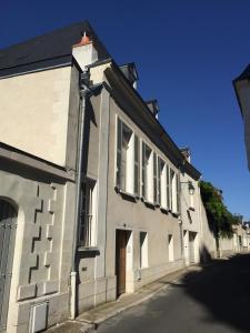 a white building with a door on a street at Coté Remparts in Amboise