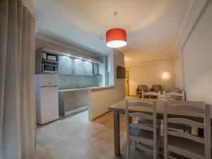 a kitchen and dining room with a table and chairs at Flor Da Rocha in Portimão