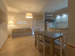 a kitchen and living room with a table and a couch at Flor Da Rocha in Portimão
