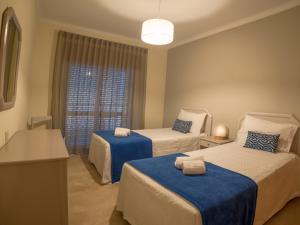a hotel room with two beds and a window at Flor Da Rocha in Portimão