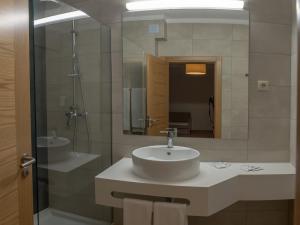 a bathroom with a sink and a mirror at Flor Da Rocha in Portimão