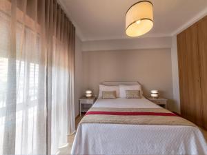 a bedroom with a bed and a large window at Flor Da Rocha in Portimão