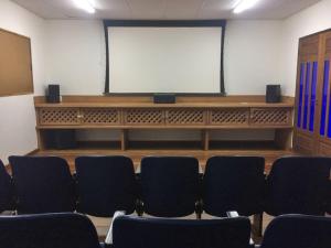 a lecture room with chairs and a projection screen at Pousada Casa Amarela in Ilhabela