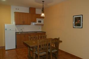 钦琼Hotel y apartamentos La Casa Rural的厨房配有木桌和白色冰箱。 更多22张照片