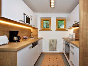 eine Küche mit weißen Schränken und Arbeitsflächen aus Holz in der Unterkunft Ferienwohnungen Margreiter in Mitterbach