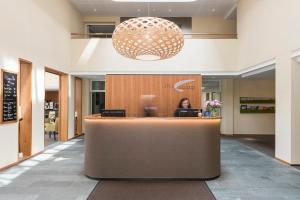 a woman sitting at a counter in a lobby at Hotel Allegra in Pontresina